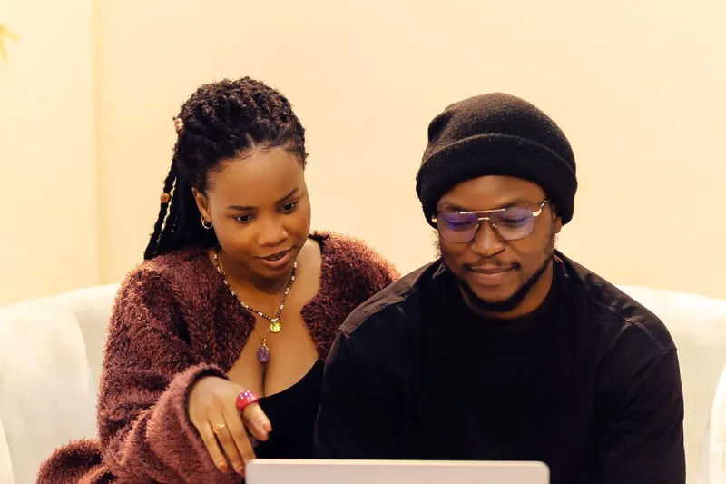 Two people discussing work together over a laptop in Lagos, Nigeria.